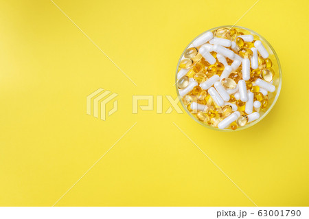 Medications vitamins tablets and pills on a plate. 63001790