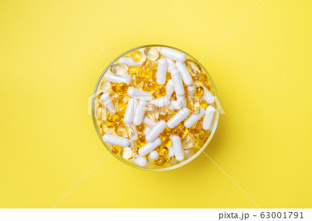 Medications vitamins tablets and pills on a plate. 63001791