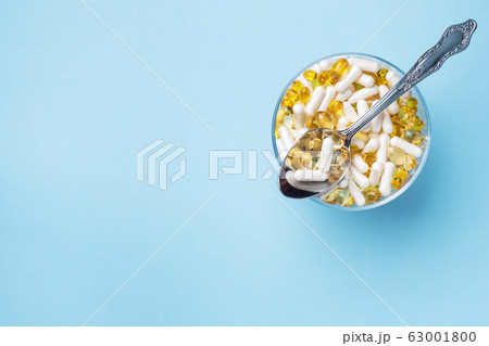 Medications vitamins tablets and pills on a plate. Medications vitamins tablets and pills on a plate. 63001800