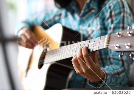 Skillful musician fingers on guitar fretboard Skillful musician fingers on guitar fretboard 63002026