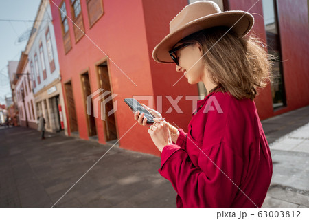 Woman with smart phone on the city street 63003812