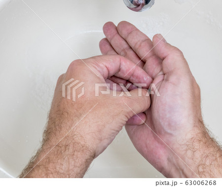 Man washing hands close-up from above Man washing hands close-up from above 63006268