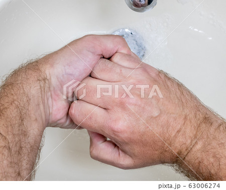 Man washing hands close-up from above Man washing hands close-up from above 63006274