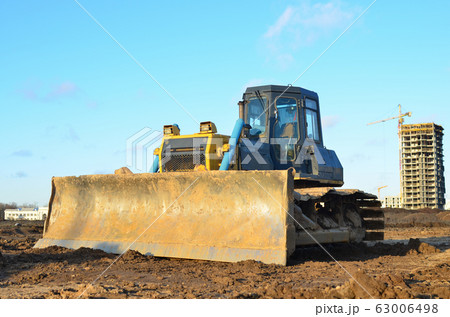 Bulldozer during land clearing and foundation digging at large construction site Bulldozer during land clearing and foundation digging at large construction site 63006498