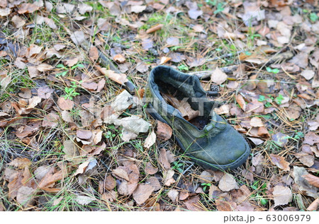 Man's shoes on a ground in the forest.  63006979