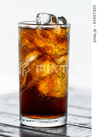 cola drink with ice in glass on wood table cola drink with ice in glass on wood table 63007895
