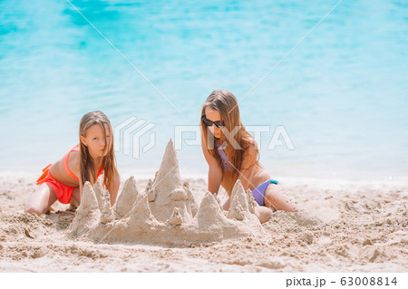 Two kids making sand castle and having fun at tropical beach Two kids making sand castle and having fun at tropical beach 63008814