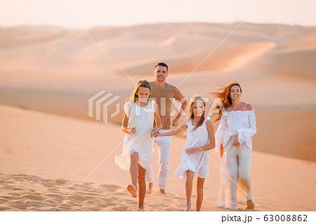 Family among dunes in Rub al-Khali desert in United Arab Emirates 63008862