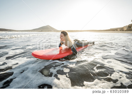 Woman swimming on the surfboard 63010389