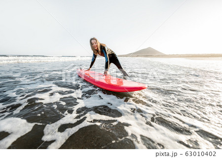 Woman surfing in the sea Woman surfing in the sea 63010402