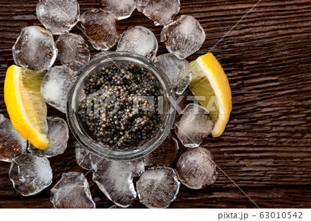 Top view of black surgeon or beluga caviar on wooden table Top view of black surgeon or beluga caviar on wooden table 63010542