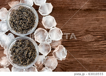 Top view of black surgeon or beluga caviar on wooden table Top view of black surgeon or beluga caviar on wooden table 63010555