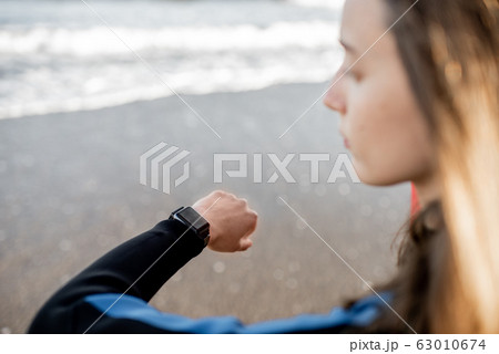 Surfer using smart watch 63010674
