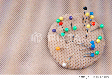 Multi-colored pins for sewing in a pillow for pins. Needlework concept. 63012469