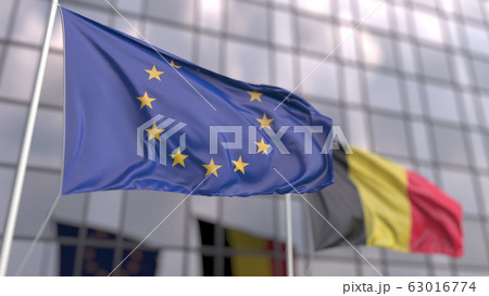 Waving flags of the EU and Belgium in front of a modern skyscraper. 3D rendering Waving flags of the EU and Belgium in front of a modern skyscraper. 3D rendering 63016774