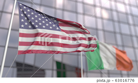 Waving flags of the USA and Ireland in front of a modern building. 3D rendering Waving flags of the USA and Ireland in front of a modern building. 3D rendering 63016776