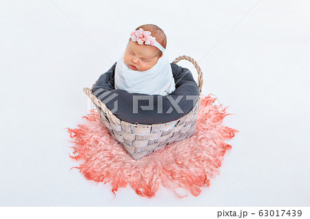 newborn baby wrapped in a blanket sleeping in a basket. concept of childhood, healthcare, IVF. newborn baby wrapped in a blanket sleeping in a basket. concept of childhood, healthcare, IVF. 63017439