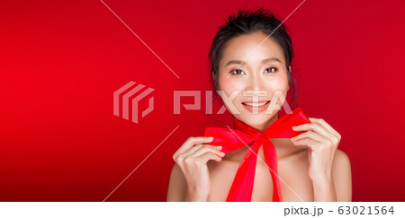 Asian tanned skin woman with strong color red lips 63021564