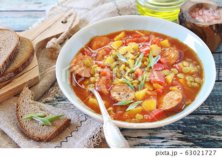 Homemade spicy pea soup with potatoes, tomatoes, sausages and slices of bread Homemade spicy pea soup with potatoes, tomatoes, sausages and slices of bread 63021727