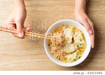 Instant noodles soup and wonton dumpling stuffed with minced pork eating by chopsticks Instant noodles soup and wonton dumpling stuffed with minced pork eating by chopsticks 63025460