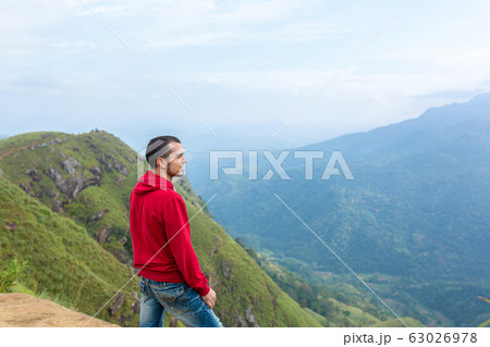 A man enjoying the mountain scenery on the edge of A man enjoying the mountain scenery on the edge of 63026978