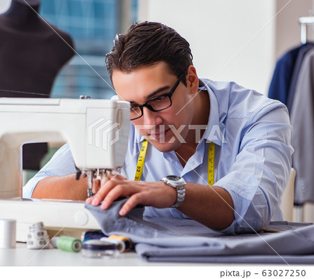 Young man tailor working on new clothing Young man tailor working on new clothing 63027250
