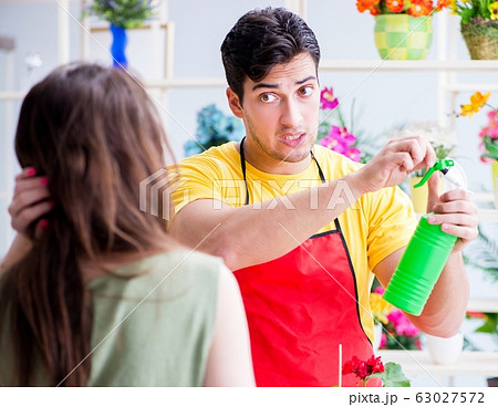 Florist selling flowers in a flower shop Florist selling flowers in a flower shop 63027572