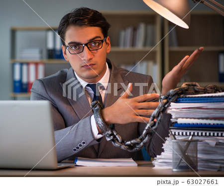 Businessman staying in the office for long hours Businessman staying in the office for long hours 63027661