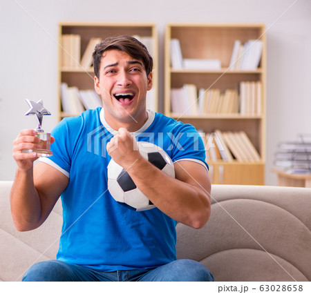 Man watching football at home sitting in couch Man watching football at home sitting in couch 63028658