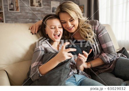 Young mother helping her little daughter with braces 63029032