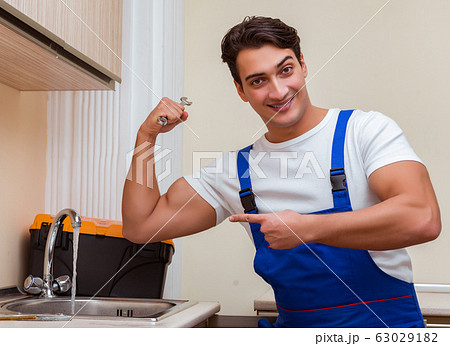 Young repairman working at the kitchen 63029182
