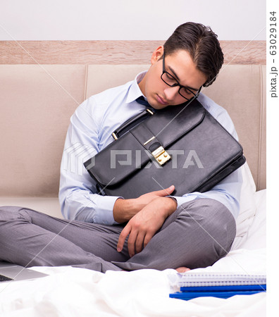 Businessman working in the bed at home 63029184