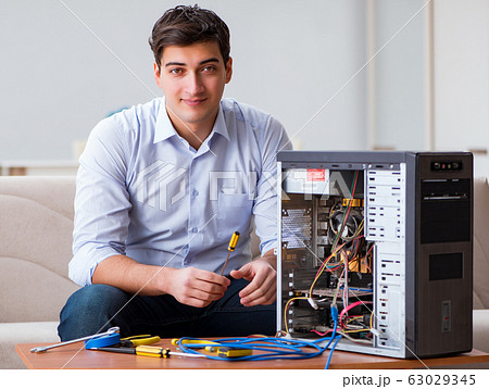 IT technician repairing broken pc desktop computer IT technician repairing broken pc desktop computer 63029345