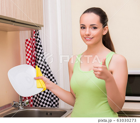 Young wife woman washing dishes in kitchen Young wife woman washing dishes in kitchen 63030273