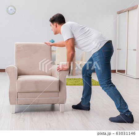 Man moving furniture at home 63031146