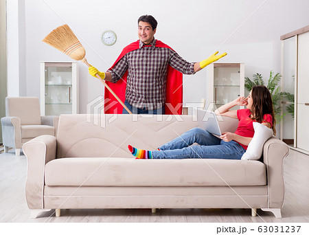 Superhero husband helping his wife at home 63031237