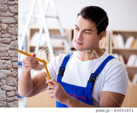 Repairman working with measurement tape Repairman working with measurement tape 63031971