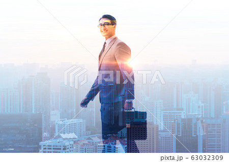 Successful businessman against cityscape in business concept Successful businessman against cityscape in business concept 63032309