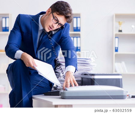 Businessman making copies in copying machine 63032559