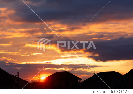 Sunset on the background of houses in the village Sunset on the background of houses in the village 63033122