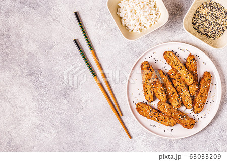 Fried tempeh  with sesame seeds. 63033209