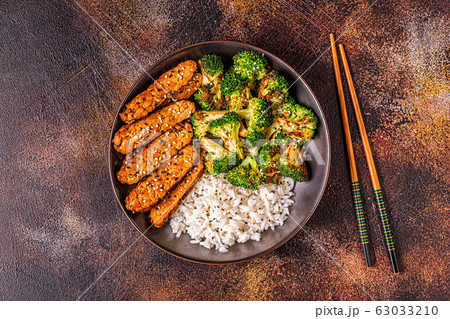 Fried tempeh with rice and broccoli. 63033210