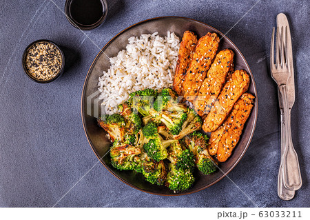 Fried tempeh with rice and broccoli. Fried tempeh with rice and broccoli. 63033211