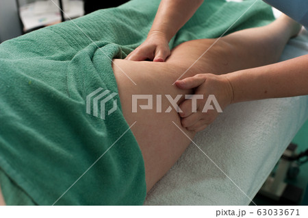 Woman massage the legs of a young unknown woman 63033671
