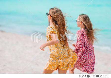 Little happy funny girls have a lot of fun at tropical beach playing together. Little happy funny girls have a lot of fun at tropical beach playing together. 63034630