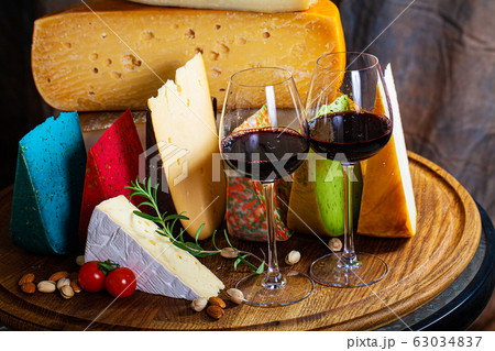 Different sorts of cheese on kitchen table. 63034837