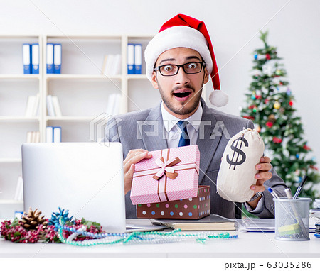 Young businessman celebrating christmas in the office Young businessman celebrating christmas in the office 63035286