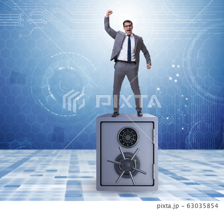 Excited businessman standing on top of safe Excited businessman standing on top of safe 63035854