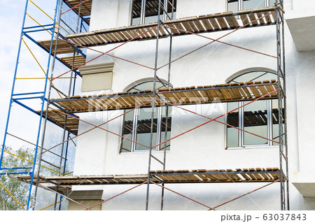 Extensive scaffolding for building a new house. Extensive scaffolding for building a new house. 63037843