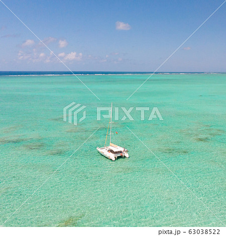 Catamaran sailing boat in turquoise sea lagoon on tropial Mauritius island. Aerial, drone view. Catamaran sailing boat in turquoise sea lagoon on tropial Mauritius island. Aerial, drone view. 63038522